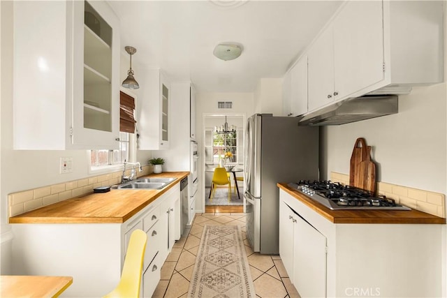 kitchen featuring under cabinet range hood, appliances with stainless steel finishes, white cabinets, and a sink