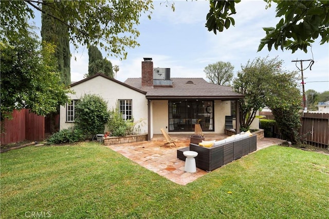 back of house with a yard, a patio area, stucco siding, and a fenced backyard