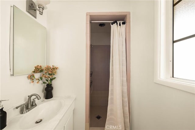 full bathroom with tiled shower and vanity