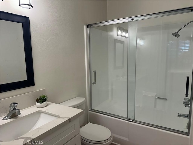 full bathroom featuring shower / bath combination with glass door, vanity, and toilet