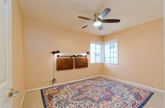 carpeted empty room with ceiling fan and baseboards