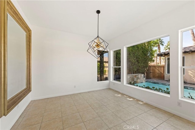 interior space featuring a healthy amount of sunlight, light tile patterned floors, and baseboards