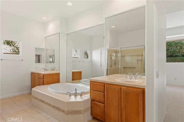 bathroom with a garden tub, two vanities, a stall shower, a sink, and tile patterned flooring