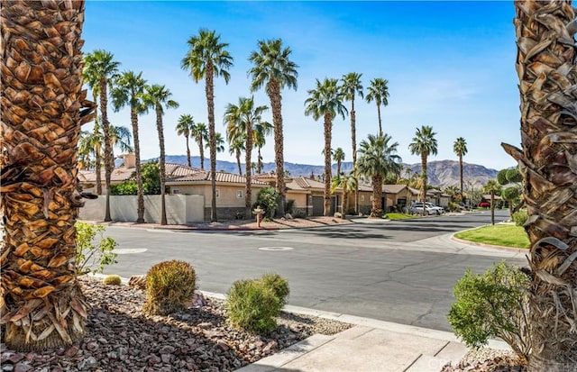 view of street with a residential view, sidewalks, a mountain view, and curbs