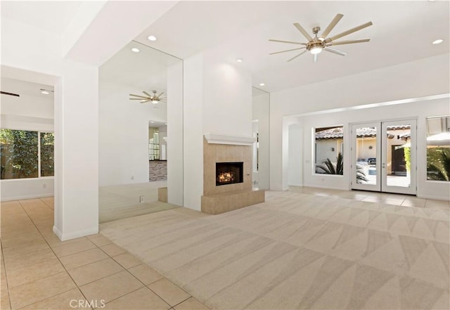 unfurnished living room with light carpet, ceiling fan, a tile fireplace, and recessed lighting