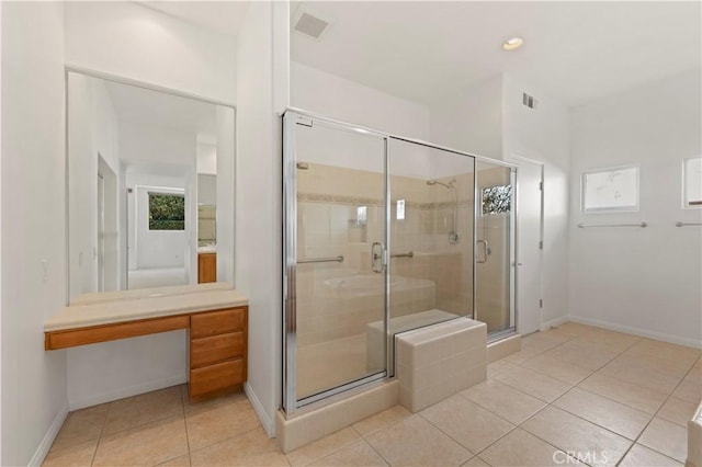 bathroom with a stall shower, baseboards, and tile patterned floors