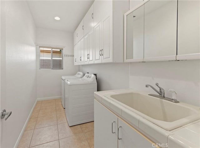 laundry room featuring washing machine and clothes dryer, cabinet space, light tile patterned flooring, a sink, and baseboards