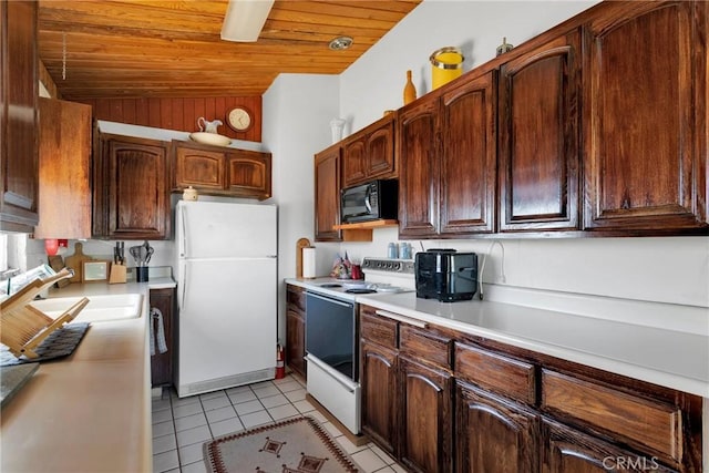 kitchen featuring white appliances, wooden ceiling, light countertops, a sink, and light tile patterned flooring