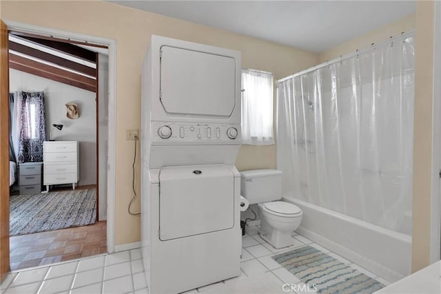 bathroom with stacked washer / dryer, tile patterned flooring, shower / tub combo with curtain, and toilet