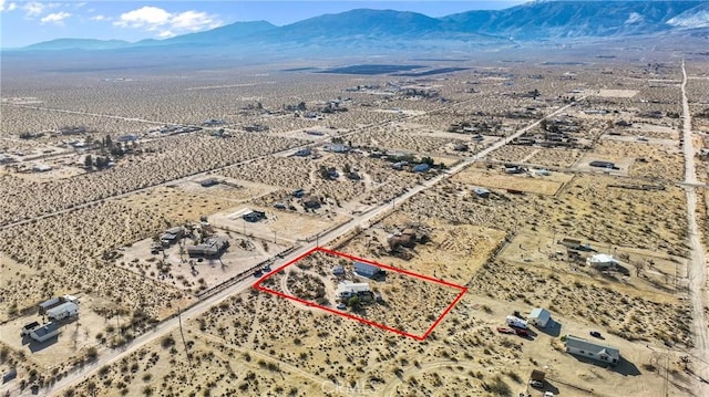 drone / aerial view featuring view of desert and a mountain view