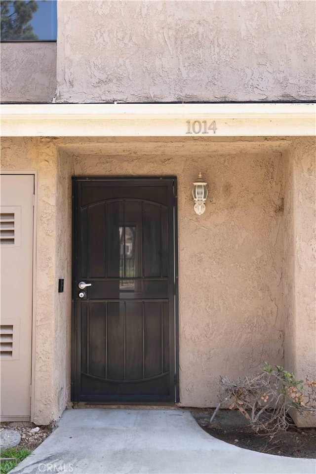 view of exterior entry with stucco siding