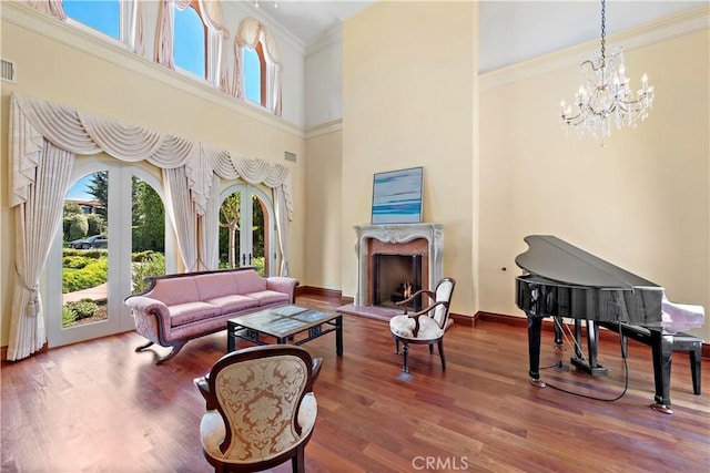 living area with ornamental molding, a fireplace, wood finished floors, and visible vents