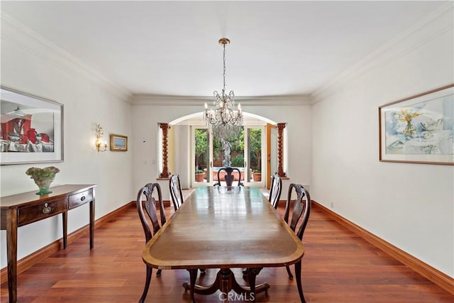 dining area featuring arched walkways, ornamental molding, wood finished floors, and baseboards