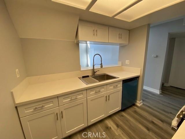 kitchen featuring dishwasher, light countertops, a sink, and white cabinetry