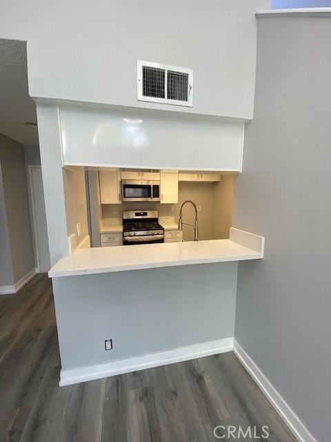 kitchen featuring a sink, visible vents, baseboards, light countertops, and appliances with stainless steel finishes