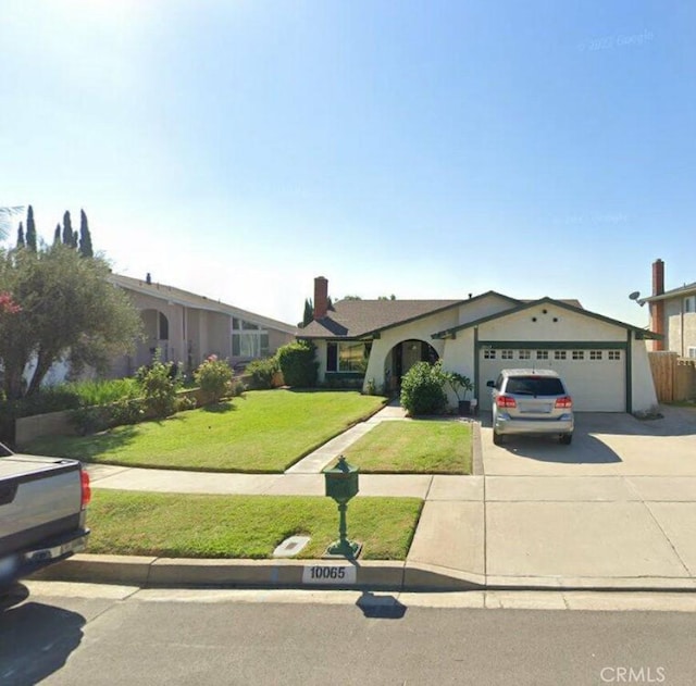 ranch-style home featuring a garage, concrete driveway, and a front lawn