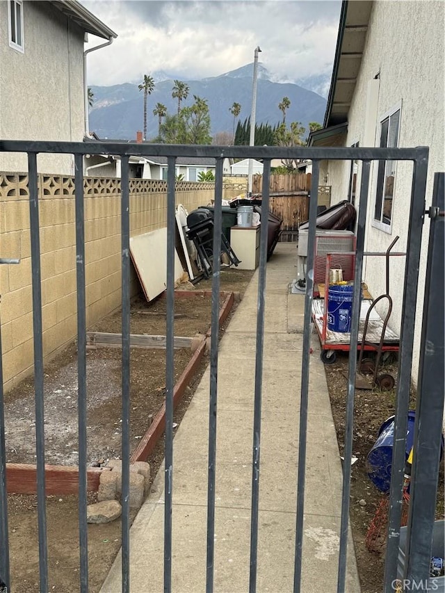 view of gate with fence and a mountain view