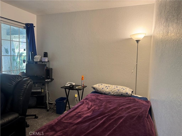 bedroom with carpet floors and a textured wall