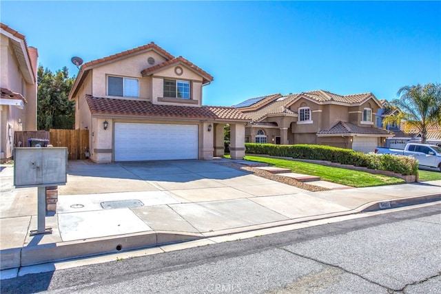 view of front of home with a tile roof, stucco siding, an attached garage, fence, and driveway