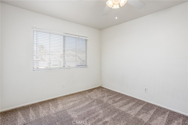 carpeted empty room with ceiling fan and baseboards