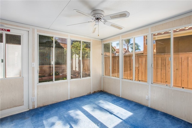 unfurnished sunroom featuring ceiling fan