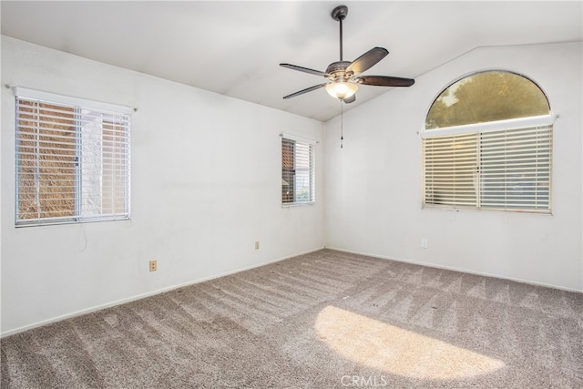 empty room with lofted ceiling, a ceiling fan, and carpet flooring