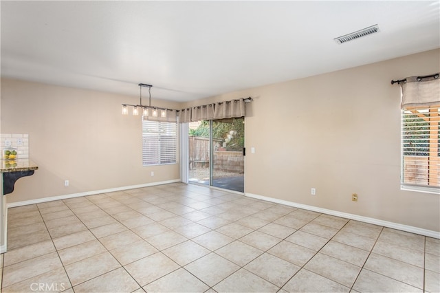 spare room with light tile patterned floors, baseboards, and visible vents