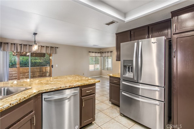 kitchen with light tile patterned floors, dark brown cabinetry, stainless steel appliances, visible vents, and decorative light fixtures