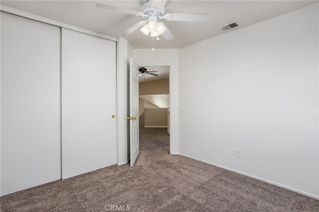 unfurnished bedroom with a ceiling fan, carpet, visible vents, and a closet