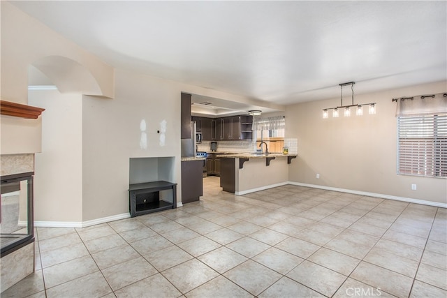 living area with baseboards and light tile patterned floors