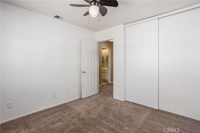 unfurnished bedroom with carpet floors, ceiling fan, visible vents, and a closet