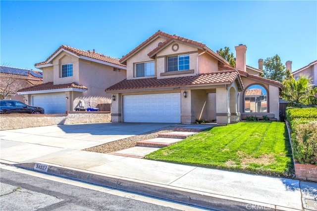 mediterranean / spanish-style home with a garage, driveway, a chimney, and a front yard