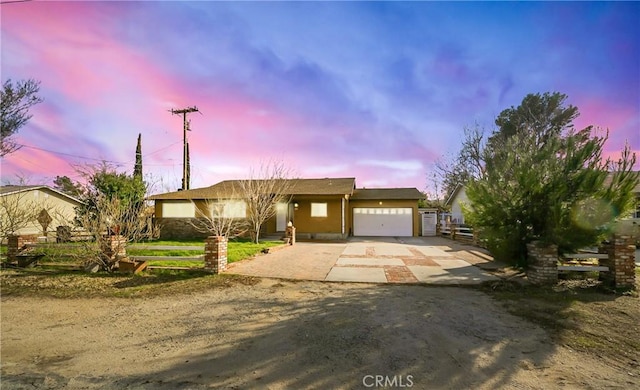 single story home with concrete driveway and an attached garage