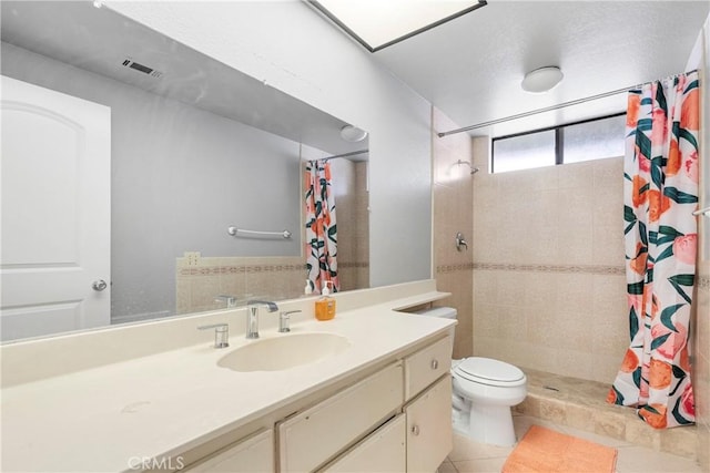 full bath featuring toilet, vanity, visible vents, a shower stall, and tile patterned floors