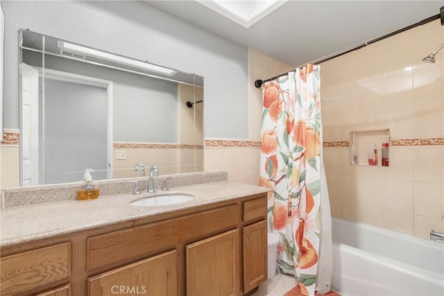 full bath featuring toilet, shower / bath combination with curtain, vanity, and tile walls