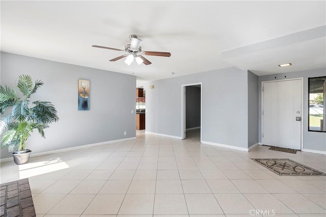 spare room with a ceiling fan, baseboards, and light tile patterned floors