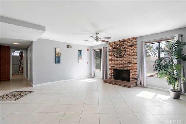 unfurnished living room with ceiling fan, light tile patterned flooring, a fireplace, visible vents, and baseboards