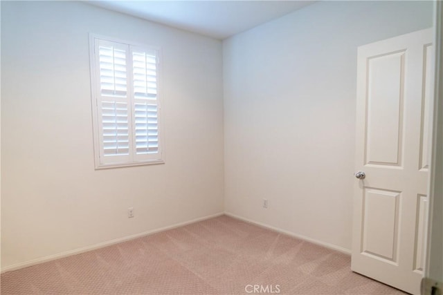 empty room with light carpet, plenty of natural light, and baseboards