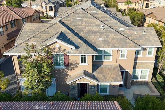 view of front of home with stone siding, a residential view, and stucco siding