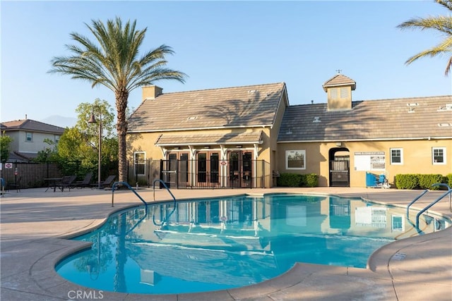 pool with a patio area and fence