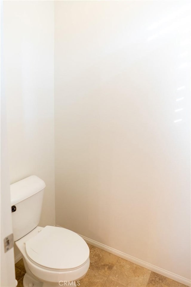 bathroom featuring toilet and baseboards