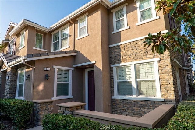 view of front of property with stone siding and stucco siding