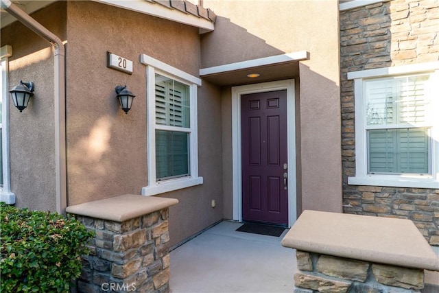 property entrance with stone siding and stucco siding