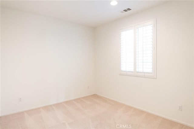 empty room featuring recessed lighting, light colored carpet, and visible vents