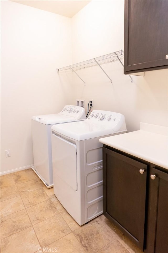 laundry room with cabinet space, washer and clothes dryer, and baseboards