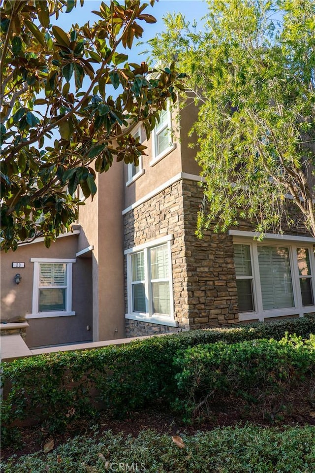 view of property exterior featuring stone siding and stucco siding