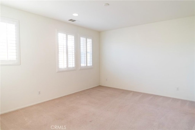 spare room with light carpet and visible vents