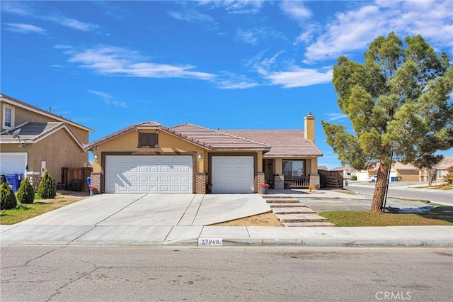 view of front of home featuring a garage, driveway, stucco siding, a tiled roof, and brick siding