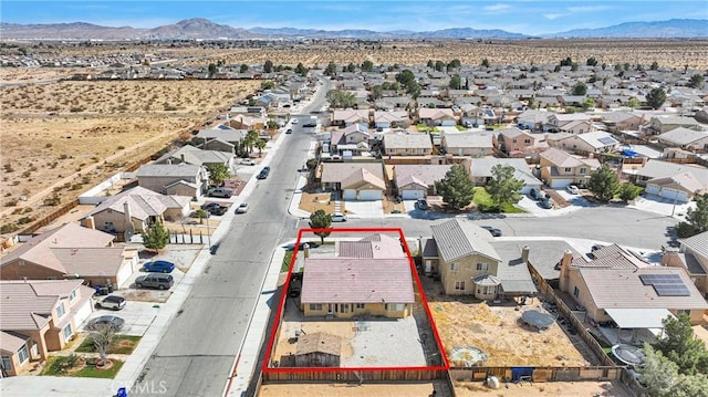 drone / aerial view featuring a residential view, a mountain view, and a desert view