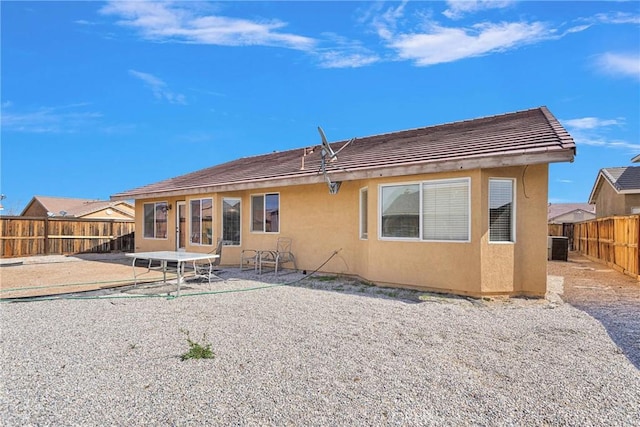 back of house with a fenced backyard, a patio, and stucco siding